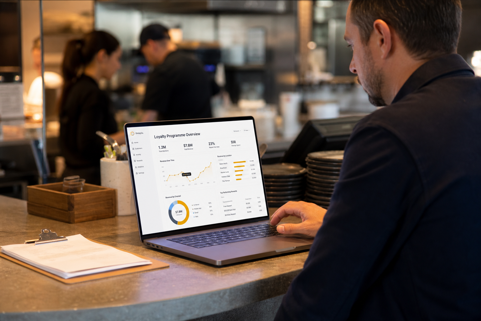 Operator reviewing loyalty programme revenue data on a laptop at a restaurant counter