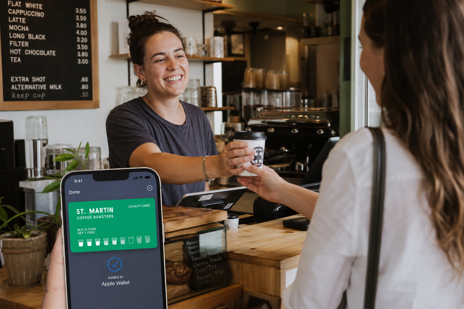 Barista handing a coffee to a customer while a loyalty card saves to their phone wallet
